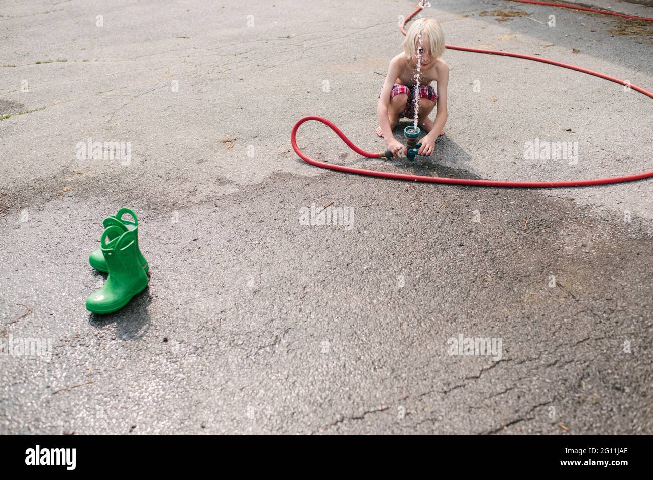 Canada, Ontario, Kingston, Shirtless boy playing with gardening hose Stock Photo