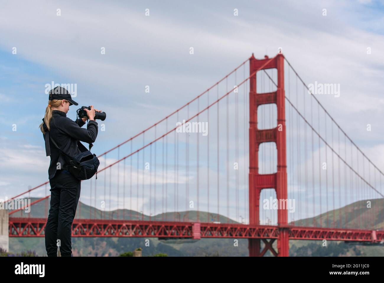 USA, CA, San Francisco, Girl photographing Golden Gate Bridge Stock Photo