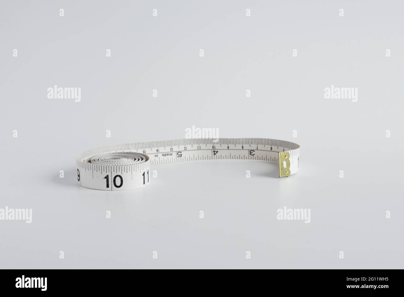 tailor's tape measure measuring inches on one side and centimeters on the other Stock Photo
