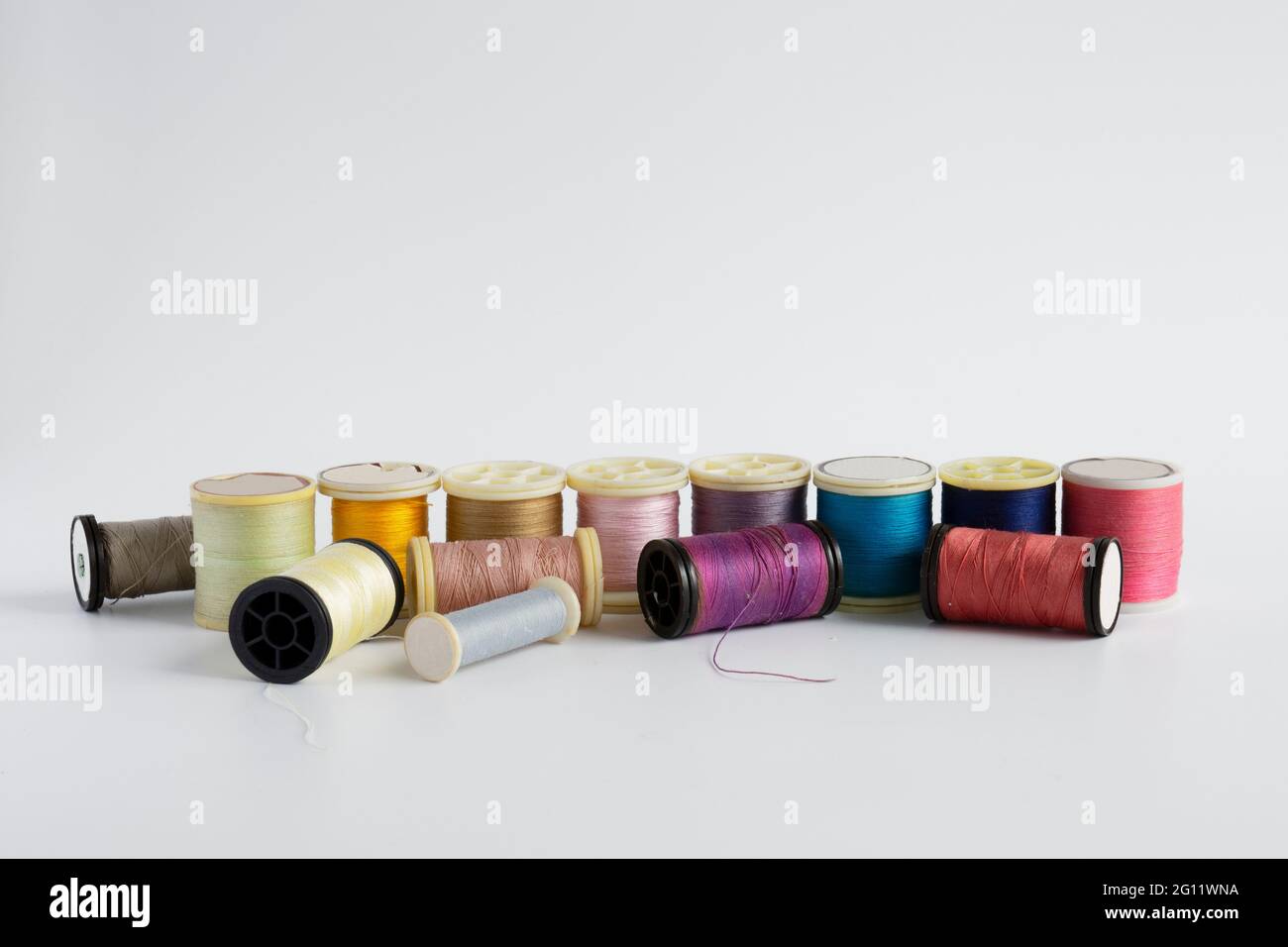 Spools of thread on a white background lined up in color Stock Photo