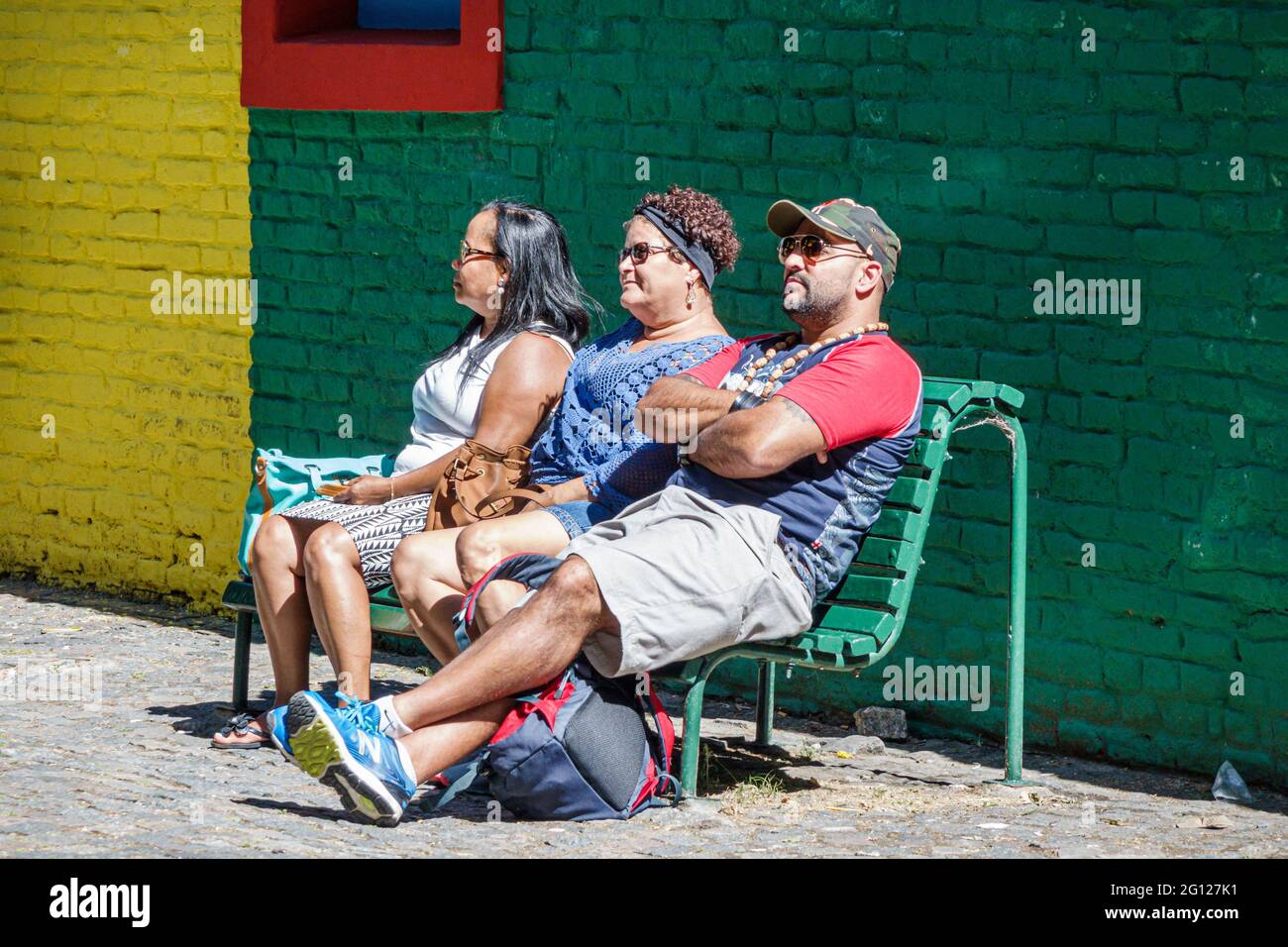 Argentina Buenos Aires Caminito Barrio de la Boca iconic neighborhood cultural landmark Hispanic man woman sitting bench resting Stock Photo