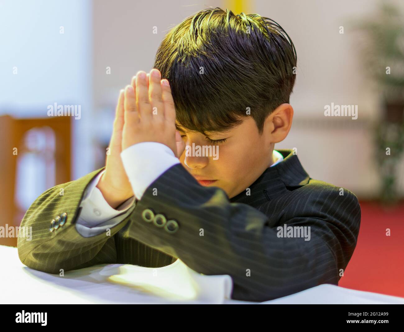 Child boy praying in a Catholic church (no release available) Stock Photo