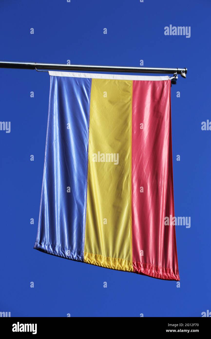 Romanian flag against a blue sky. Stock Photo