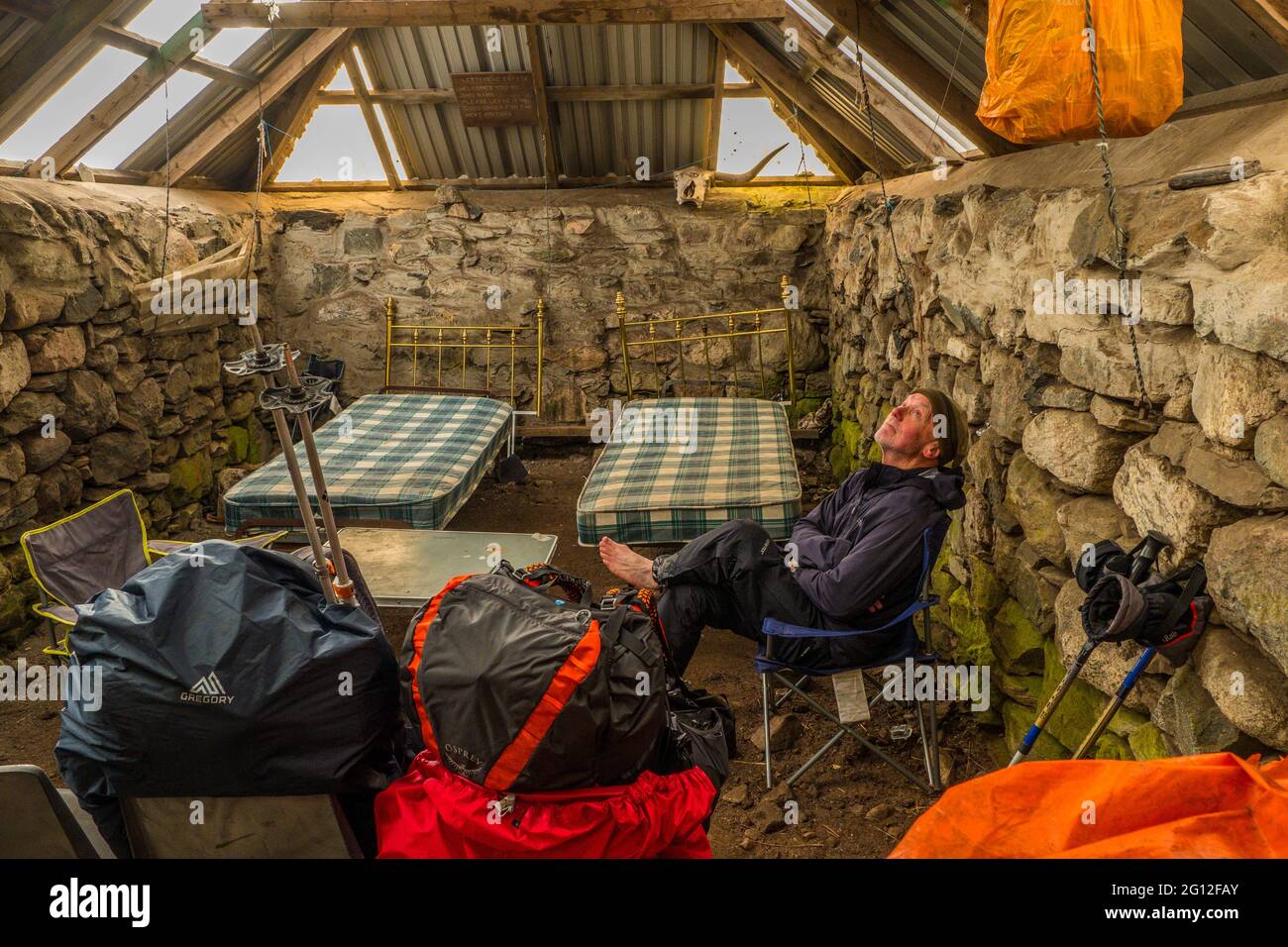 Male backpacker in a Scottish bothy Stock Photo