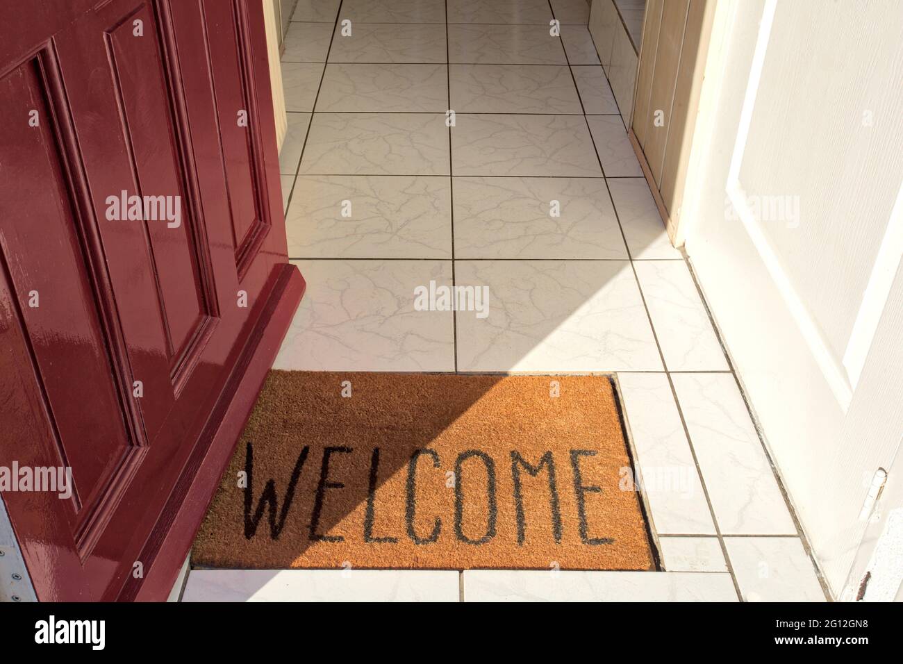 Open front door of house with door mat entering in the Hallway