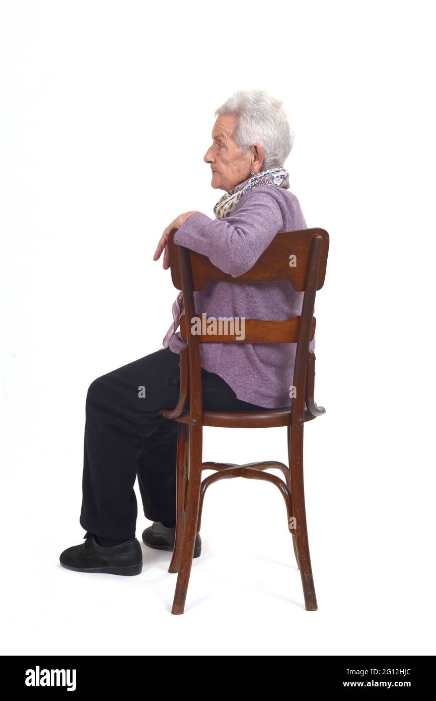 senior woman sitting on chair of profle on white background. Stock Photo