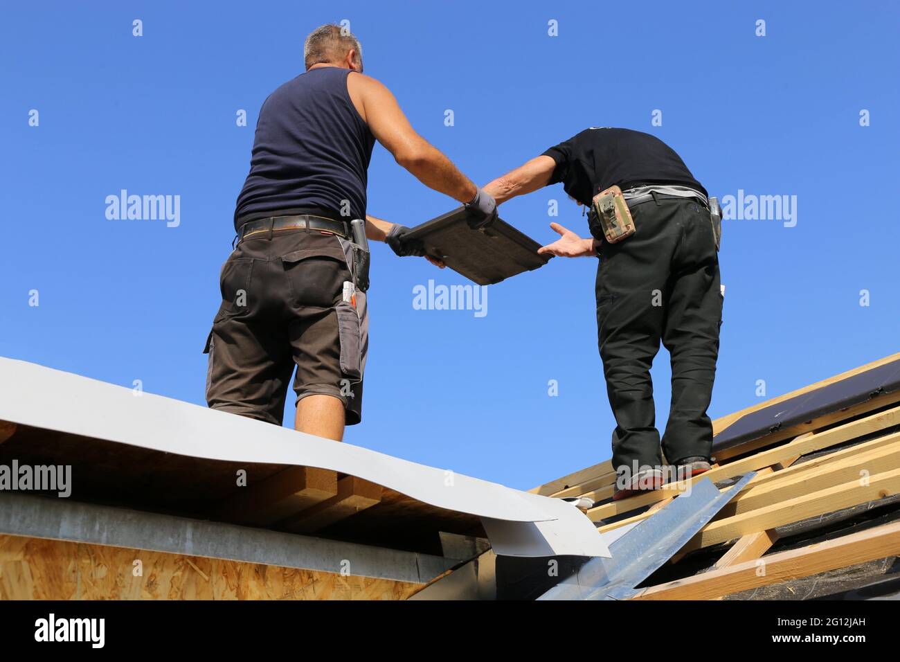 Roofing work, new covering of a tiled roof. Stock Photo