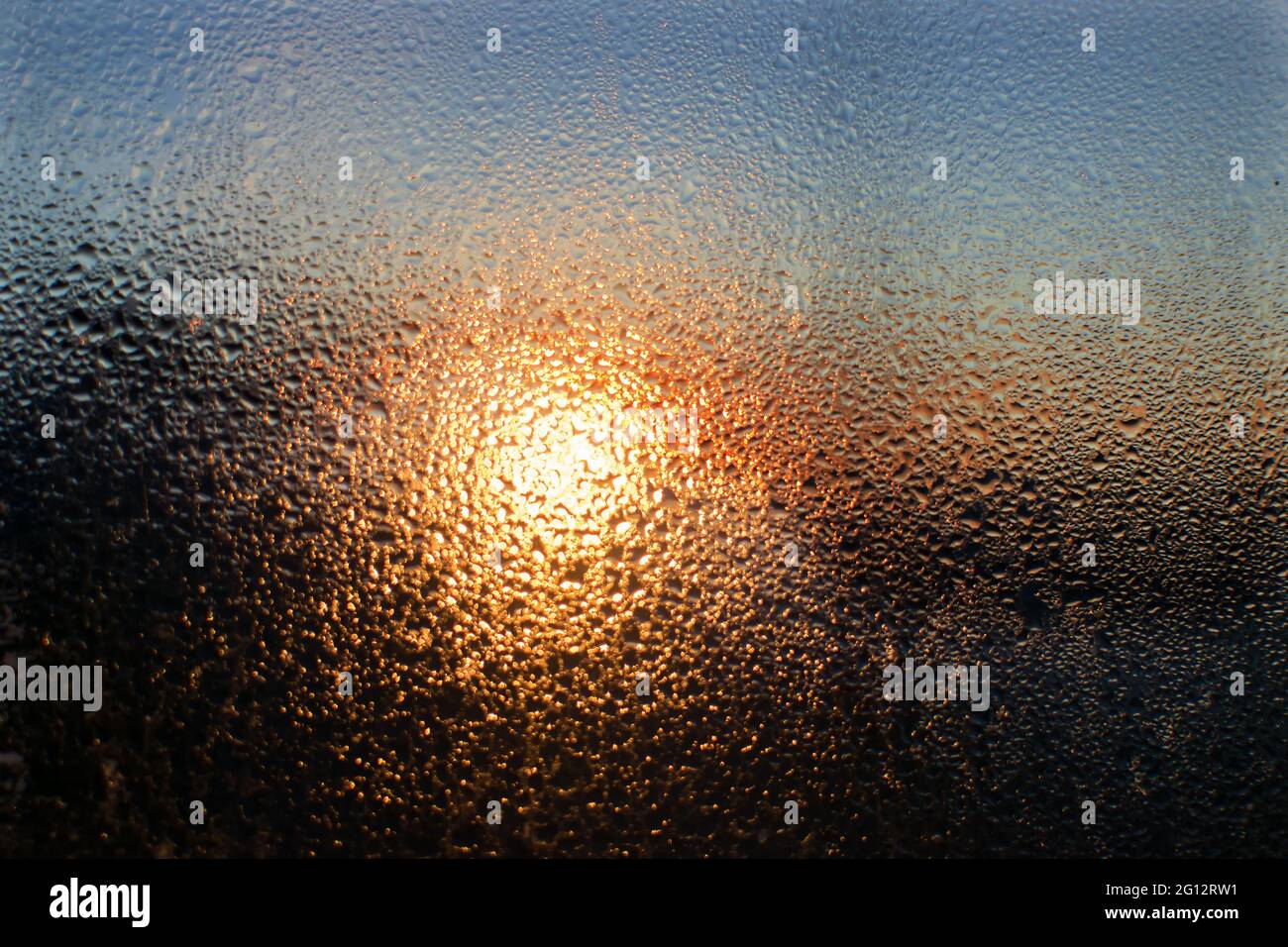 Sunrise shot behind glass filled with dew drops, abstract image, Kanchenjunga mountain range in the morning, Ravangla, Sikkim. Scenic view. Stock Photo