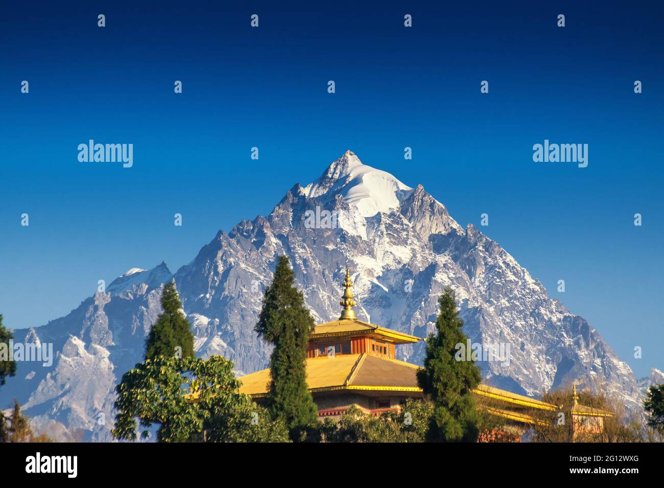 Mount Pandim, 6691 mtrs, 21952 feet high, one of the highest peaks of Himalayan Mountain range - with top of Rinchenpong Monastery in foreground. Stock Photo