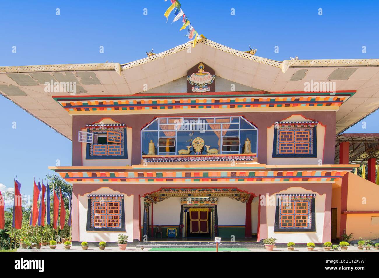 Gurung monastery - a beautiful sunlit Buddhist Monastery at Rinchenpong, Sikkim , India. Blue clear sky above and Buddhist prayer flags around. Stock Photo