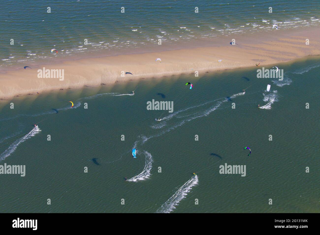 Kitesurfers / kiteboarders pulled by power kites on windy day on the North Sea Stock Photo