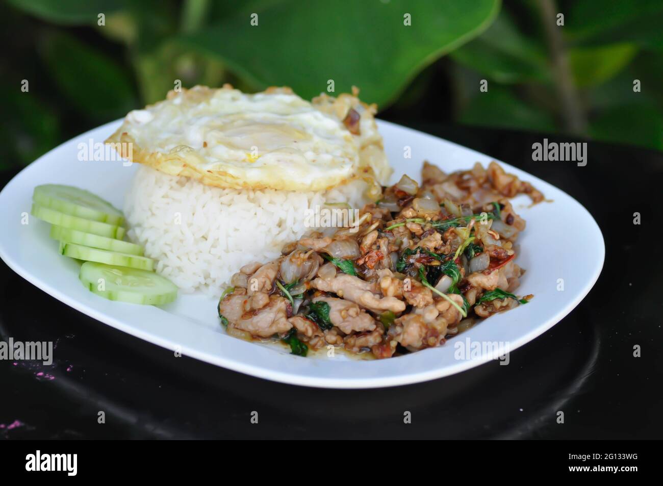 stir fried pork with holy basil , sunny side up egg and rice or Thai food Stock Photo