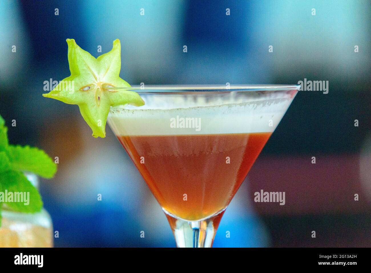 Detail of a glass with a cocktail garnished with a cut of carambola, Chinese fruit, Valencia, Spain Stock Photo