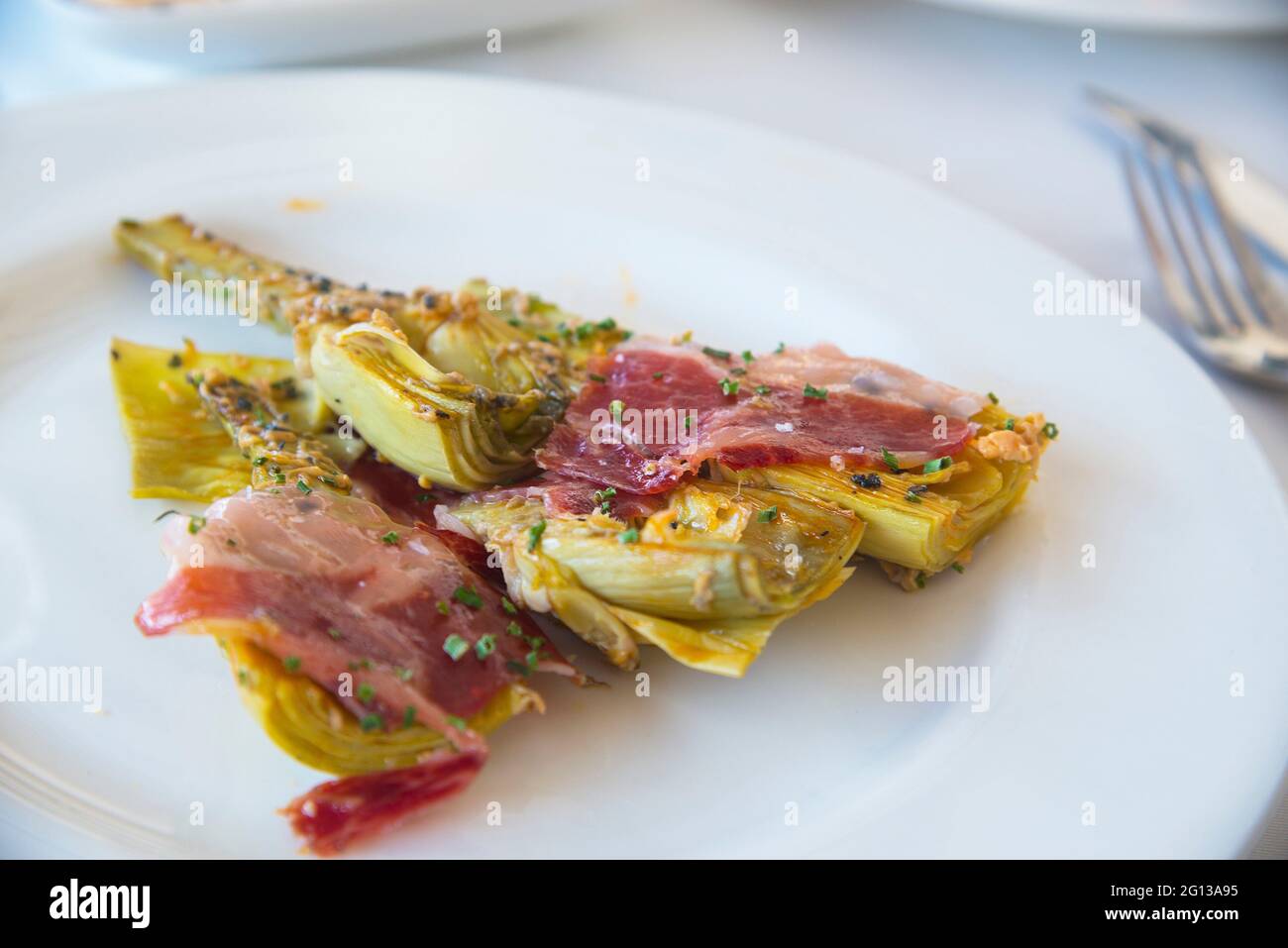 Artichokes with Iberian ham. Spain. Stock Photo