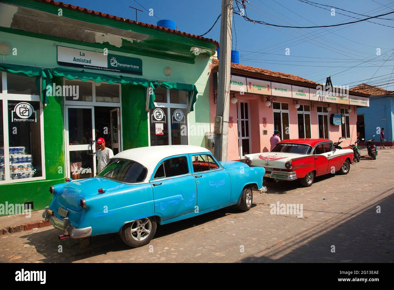 Old American cars parked in front of the shops at the town center ...