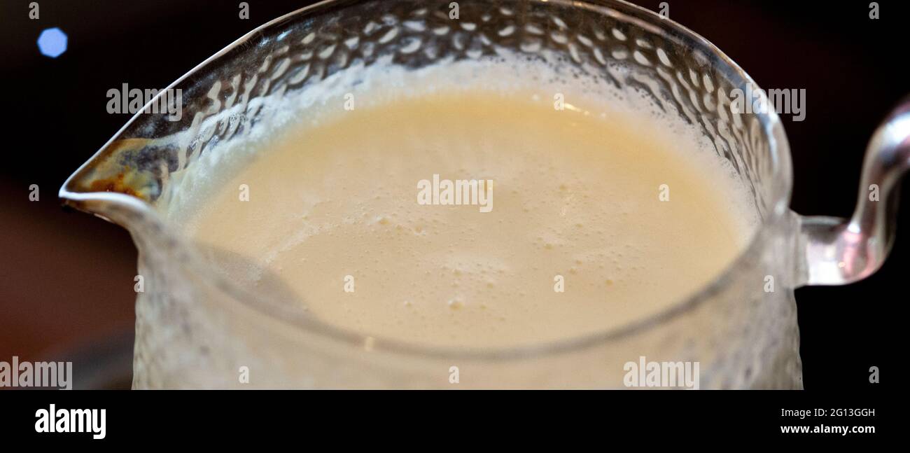 Boiled milk in a glass jar with a handle and spout Stock Photo Alamy