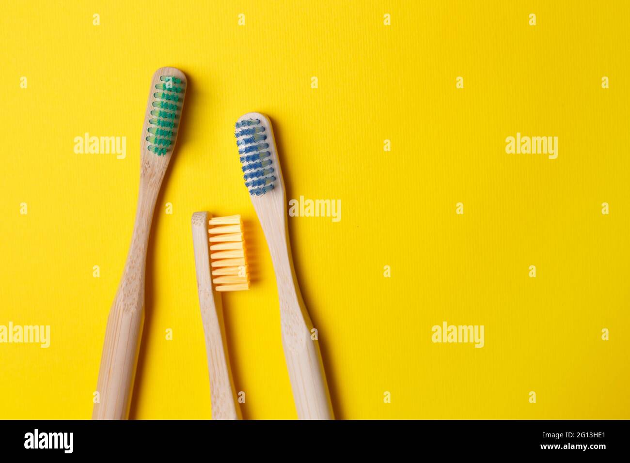 care for the environment - wooden bright toothbrushes on a yellow ...