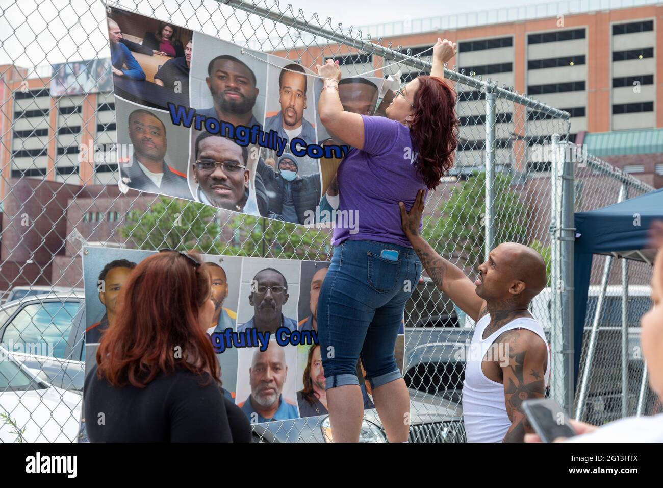 Detroit, Michigan, USA. 4th June, 2021. Family and friends of prisoners they say were wrongfully convicted rally outside the criminal courts building, the Frank Murphy Hall of Justice. Jennifer Gross, whose fiance Robert Vermett is in prison, puts up a banner before the rally. Credit: Jim West/Alamy Live News Stock Photo