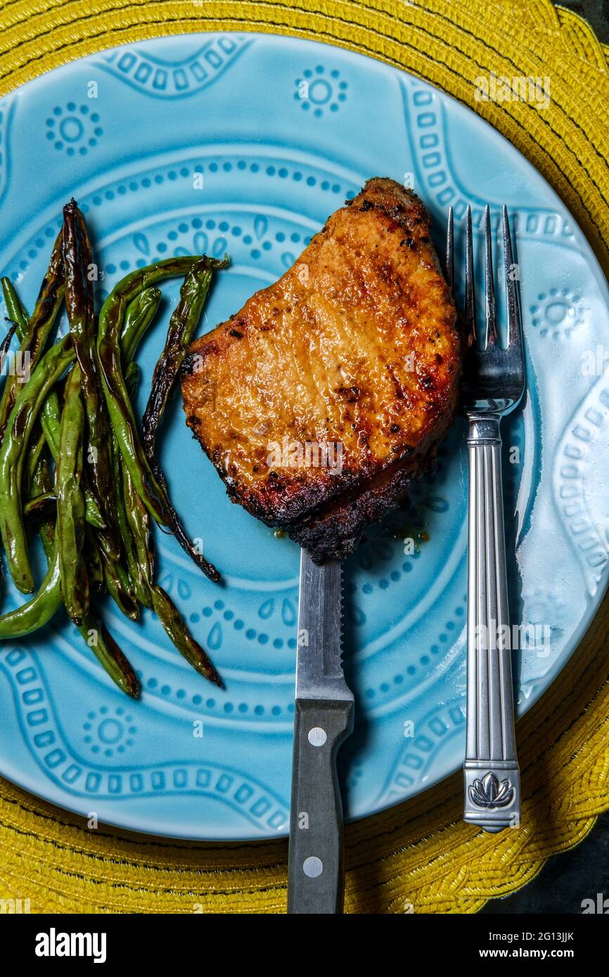 Marinated chargrilled pork chops with green beans Stock Photo Alamy