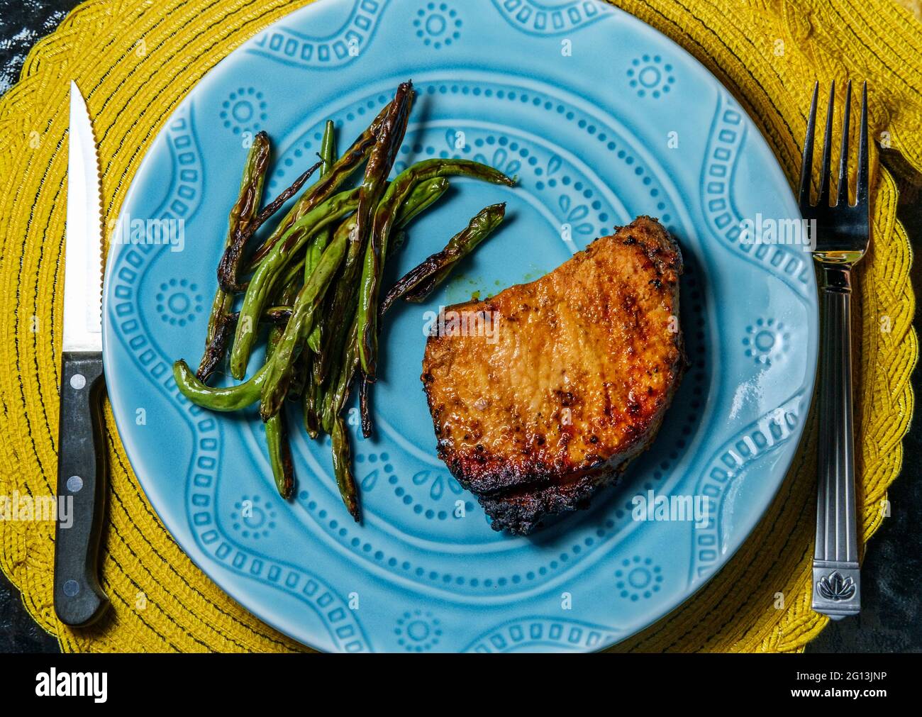 Marinated chargrilled pork chops with green beans Stock Photo Alamy