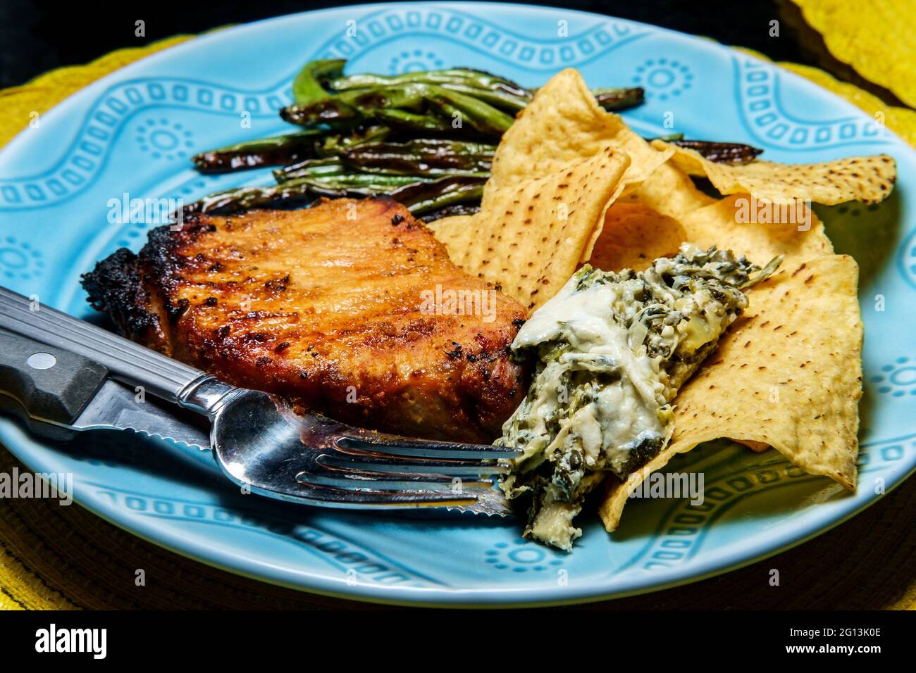 Marinated chargrilled pork chops with green beans and artichoke
