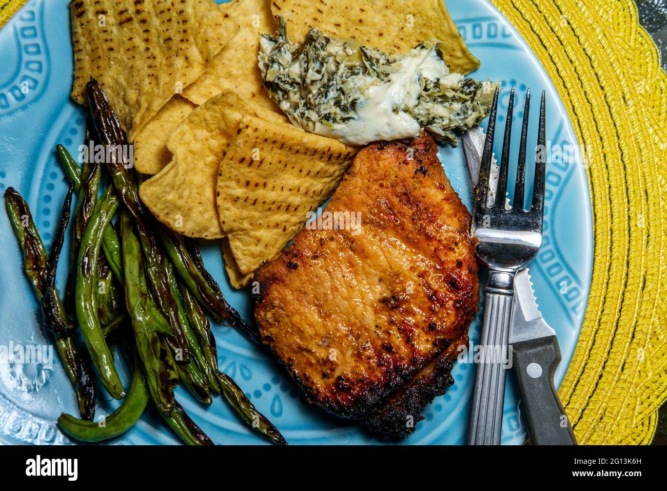 Marinated chargrilled pork chops with green beans and artichoke