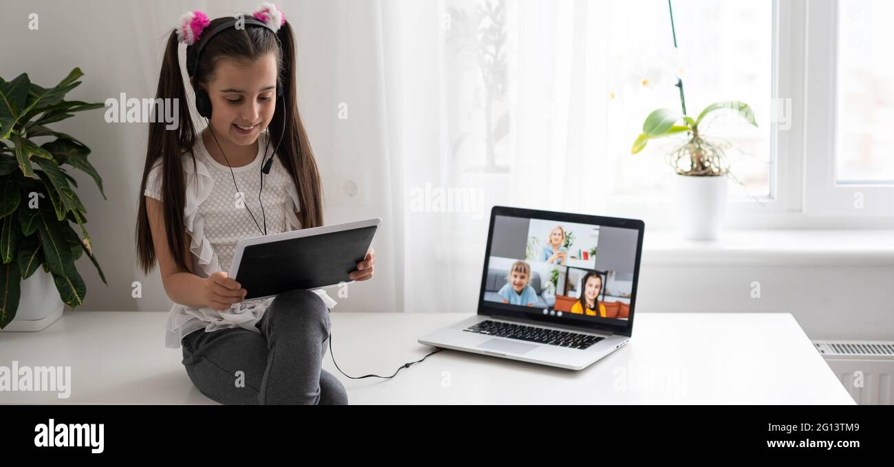 Little girl studying online using her laptop at home Stock Photo - Alamy