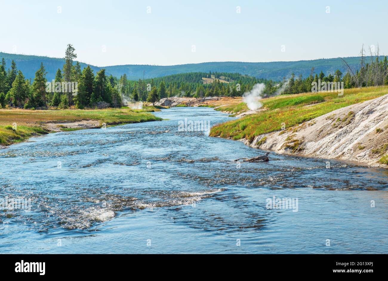 Yellowstone river in summer with fumarole volcanic activity, Yellowstone national park, Wyoming, United States of America, USA. Focus on riverbank. Stock Photo