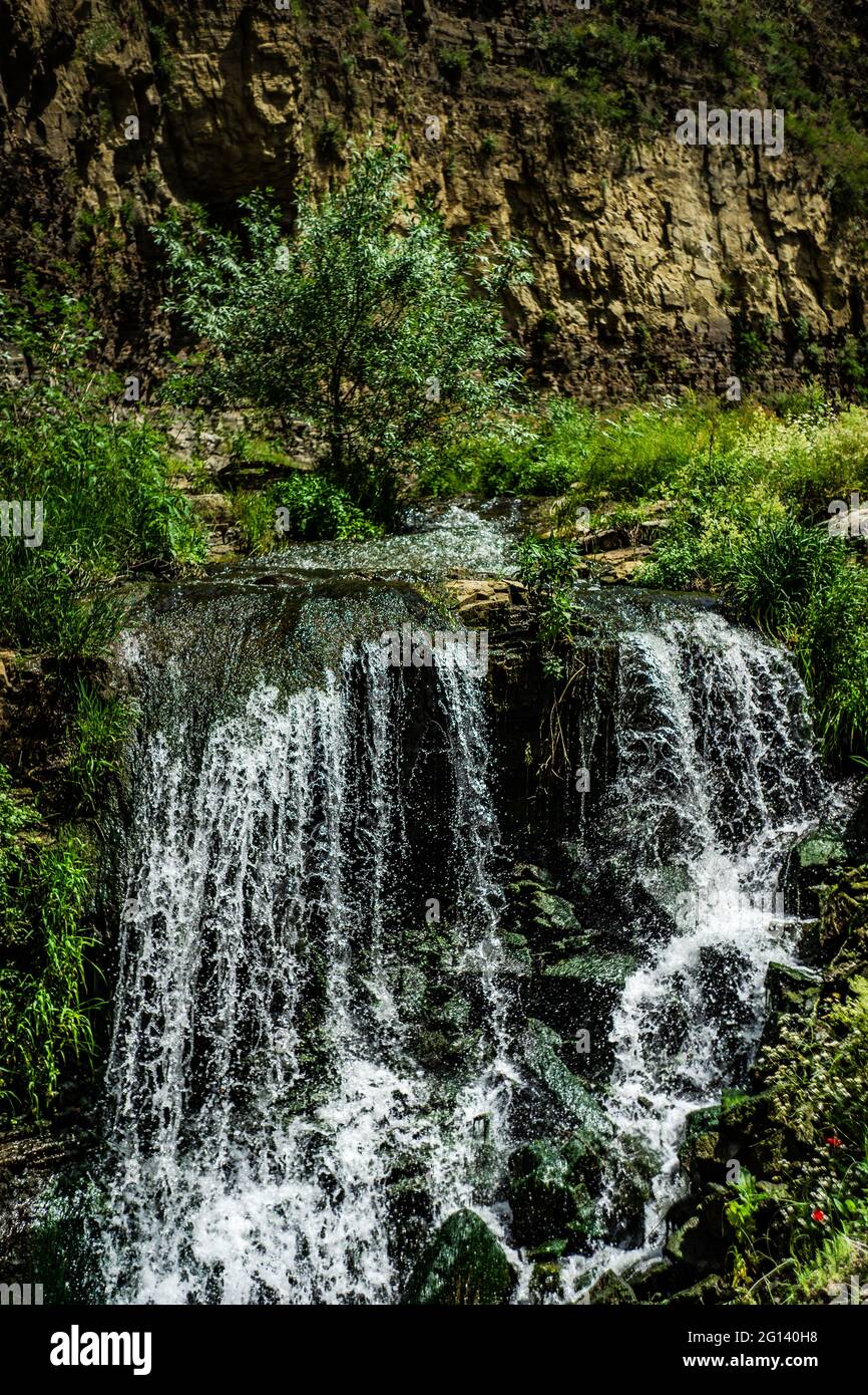 Summer background with waterfall stream among rocks Stock Photo