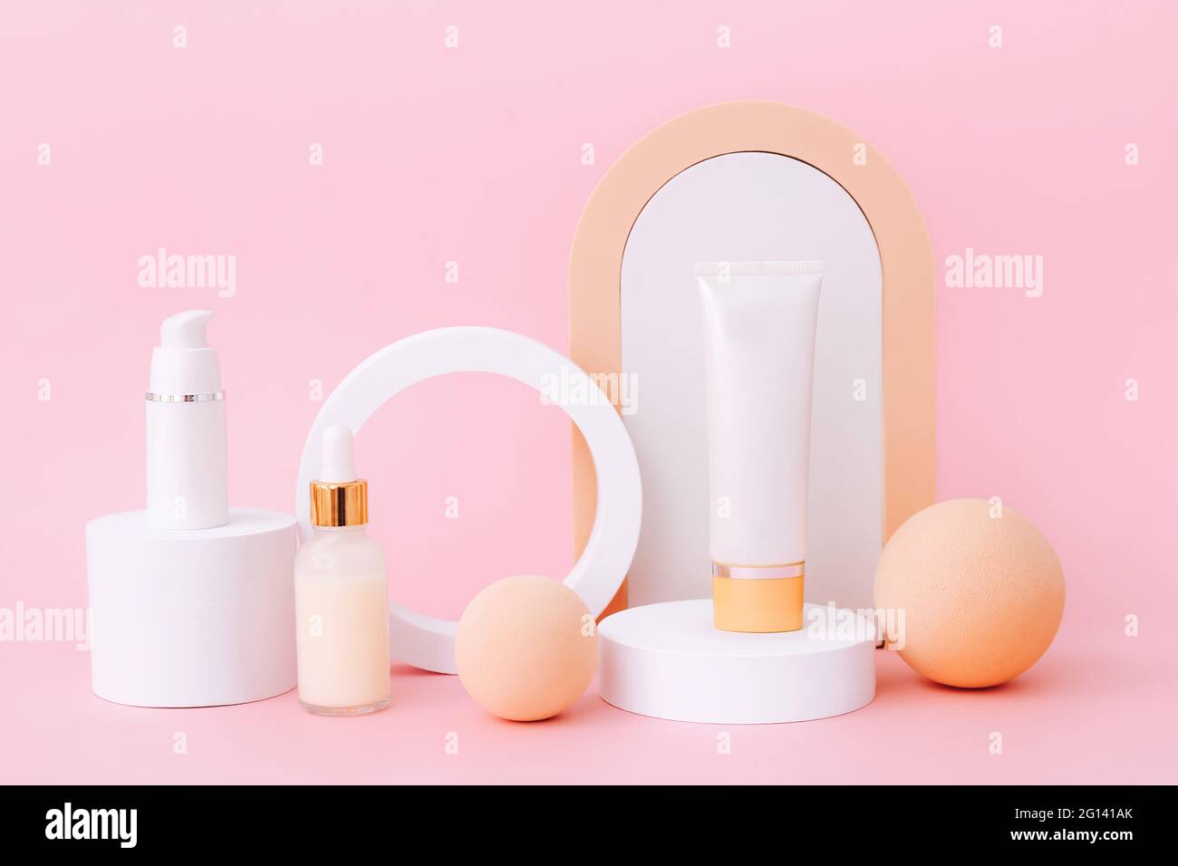 Cosmetic bottles on the geometric podiums. Presentation template for natural beauty products on pink background Stock Photo