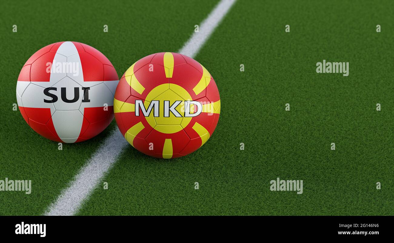 North Macedonia vs. Switzerland Soccer Match - Leather balls in North Macedonia and Switzerland national colors on a soccer field. Stock Photo