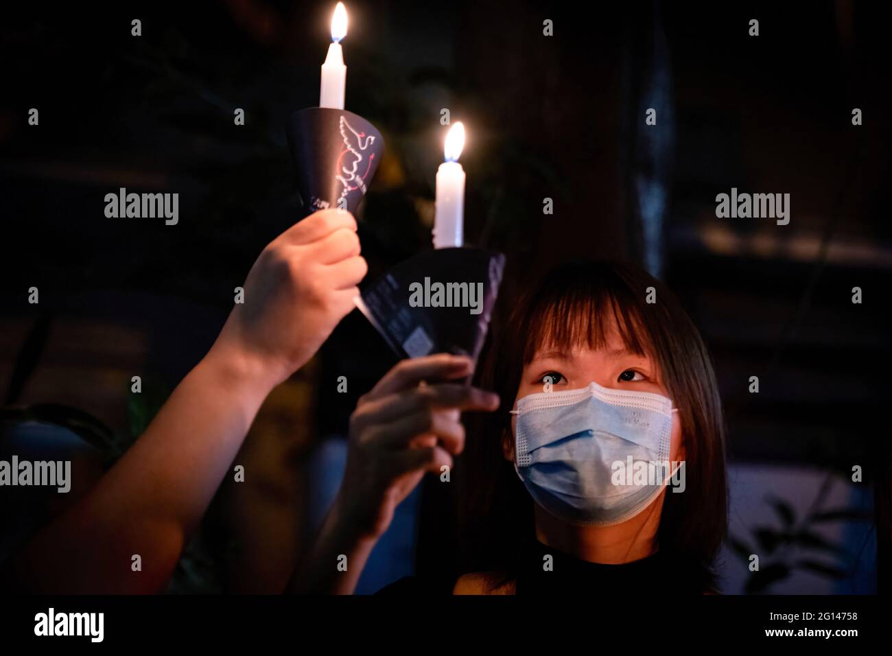 Hong Kong, China. 04th June, 2021. A woman holds a burning candle as part of the small protests by Hong Kong people during the anniversary. Police blocked off Hong Kong Victoria Park to prevent people gathering to commemorate the 32nd anniversary of China's 1989 Tiananmen Square crackdown and arrested the planned vigil organisers. Credit: SOPA Images Limited/Alamy Live News Stock Photo