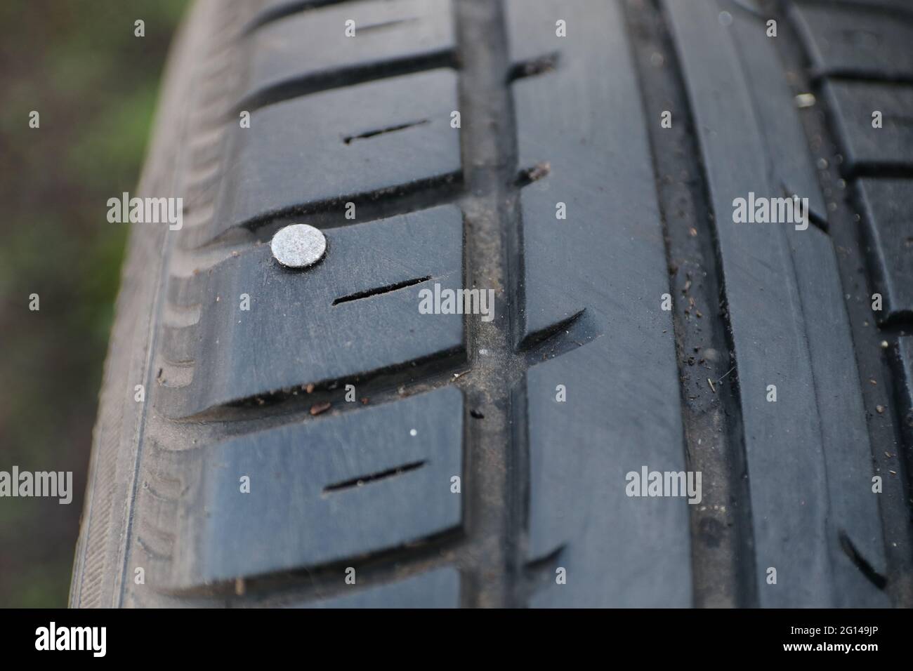 Nail in a car tyre. This may cause a puncture Stock Photo - Alamy