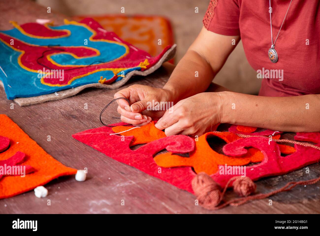 Sewing felt pieces to make felt pillow cases in Issyk Kul, Kyrgyzstan Stock Photo