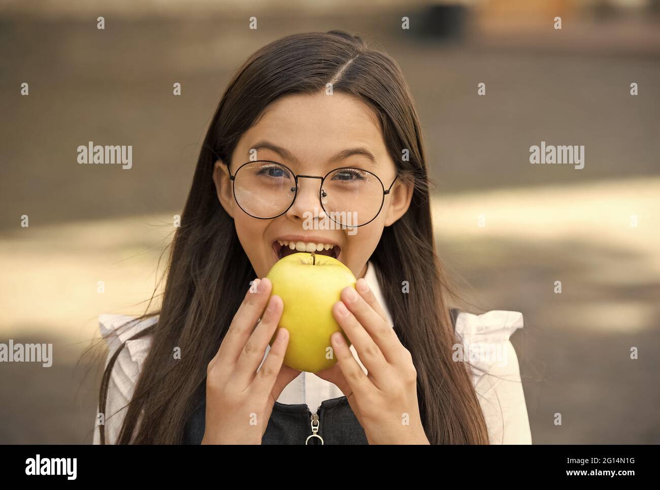 Food for your teeth. Little child bite apple outdoors. School snack