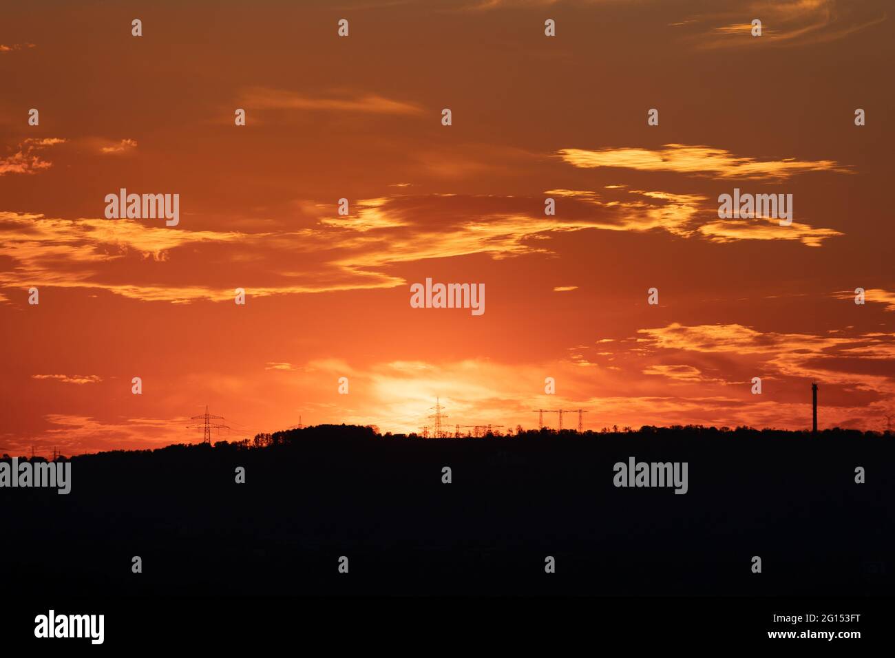 silhouette of high voltage power lines and pylons against a beautiful ...