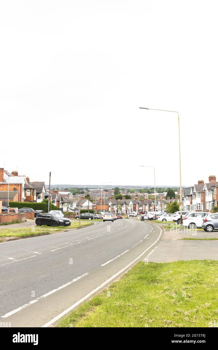 Looks down the hill and road, tops of houses, countryside and high buildings in the city centre, then with Charnwood Forest in the hills. Stock Photo