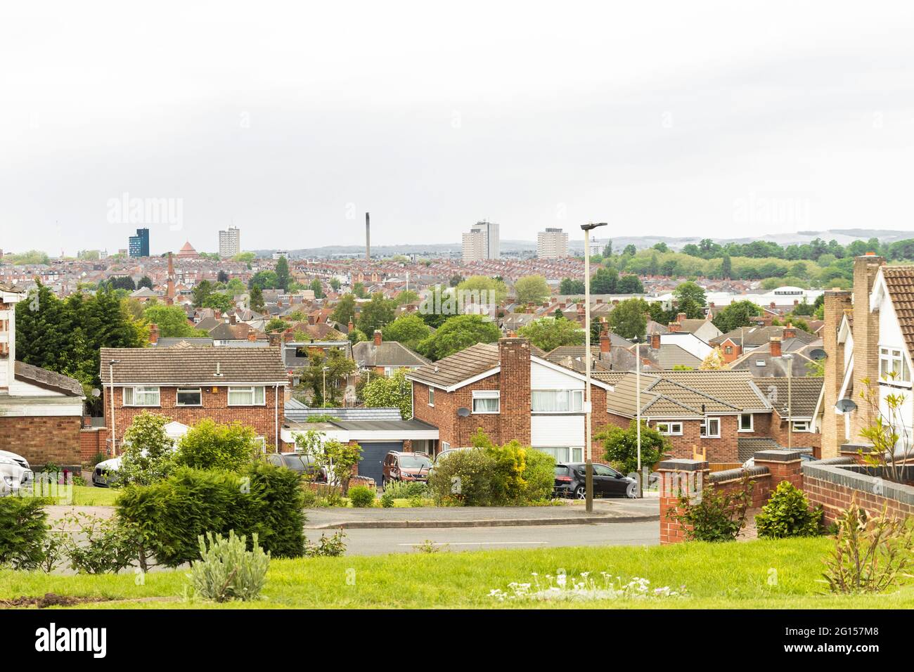 Looking over tops of houses and Leicester city centre skyline, tower blocks, St. George’s Tower, Charnwood Forest in the hills. Stock Photo