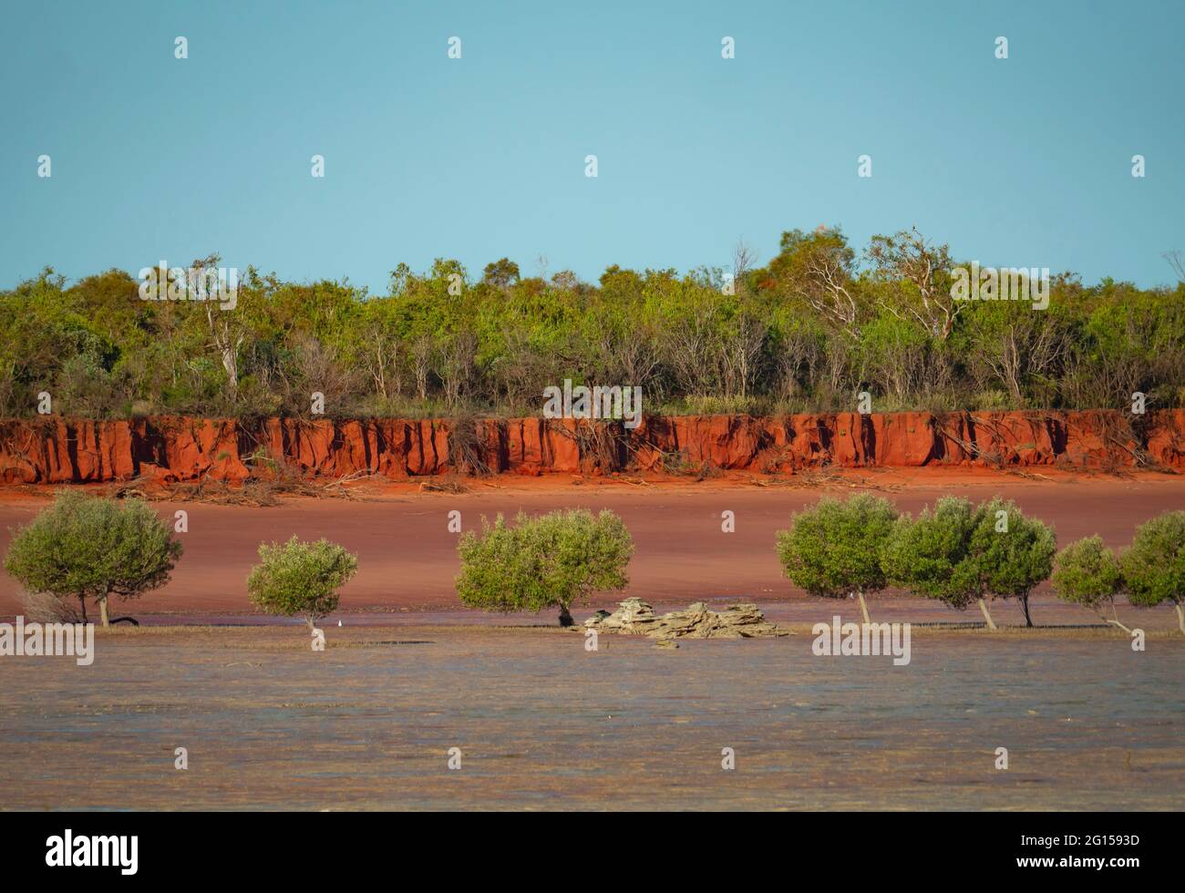 Red sand blue water and green mangroves at Roebuck Bay near Broome Western Australia with blue sky Stock Photo