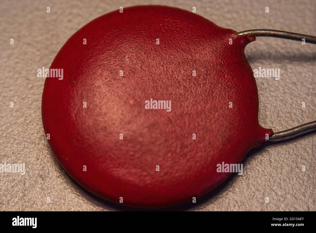 an old ceramic capacitor, texture, red Stock Photo