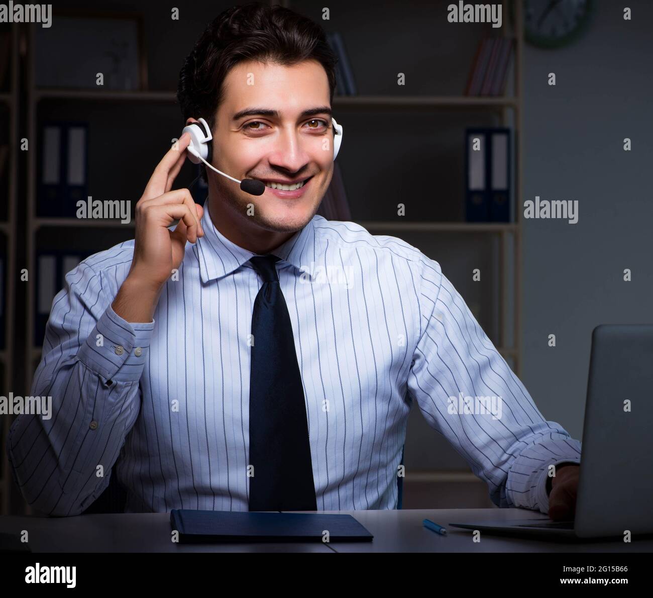 The call center operator talking to customer during night shift Stock