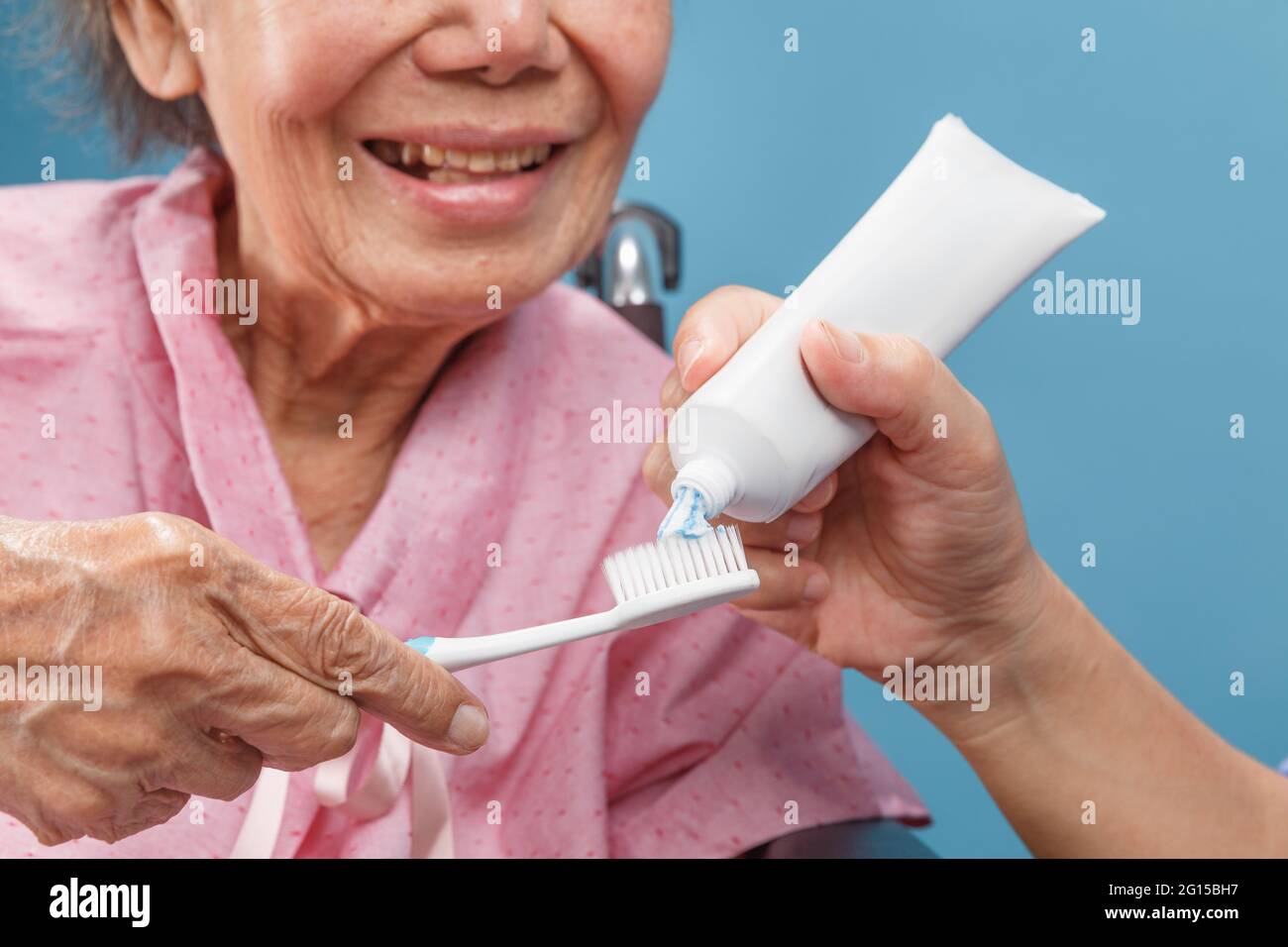 Caregiver take care asian elderly woman while using toothbrush. Stock Photo