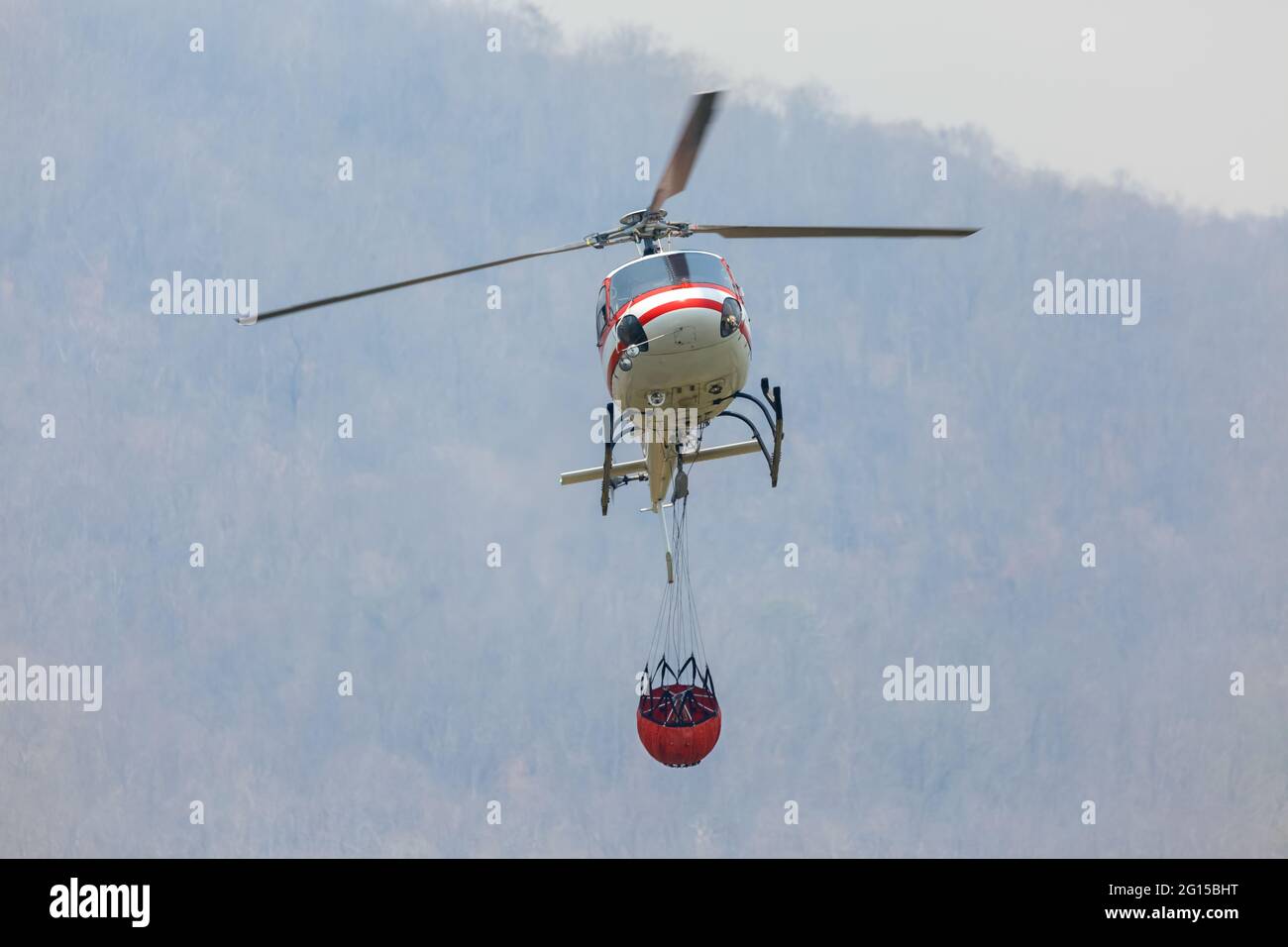 Firefighting helicopter carrying water bucket for extinguish forest