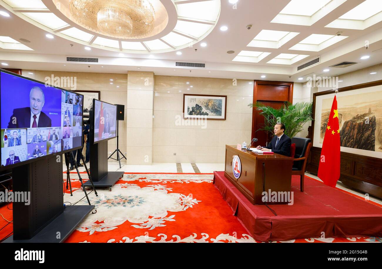 Beijing, China. 5th June, 2021. Russian President Vladimir Putin (on  screen) answers a question from He Ping (R), president and editor-in-chief  of Xinhua News Agency, on China-Russia relations, in a meeting with