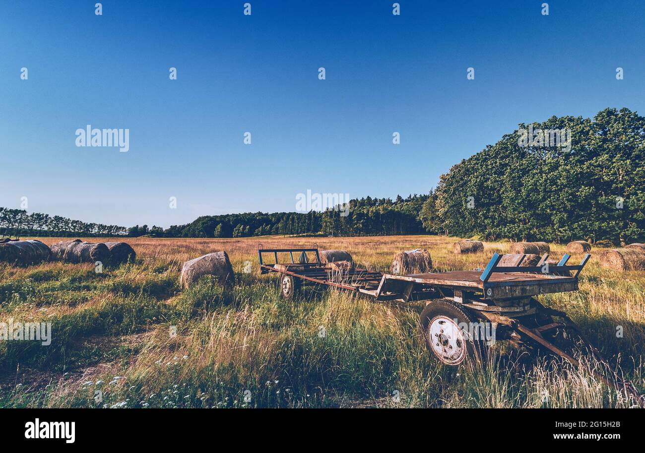 Erntemaschine Feld und Wiesen - EIn leerstehendes landwirtschaftliches Fahrzeuge im Sommer - Bäuerlich Ackerbau - Landwirtschaft - Pflugfeld Stock Photo