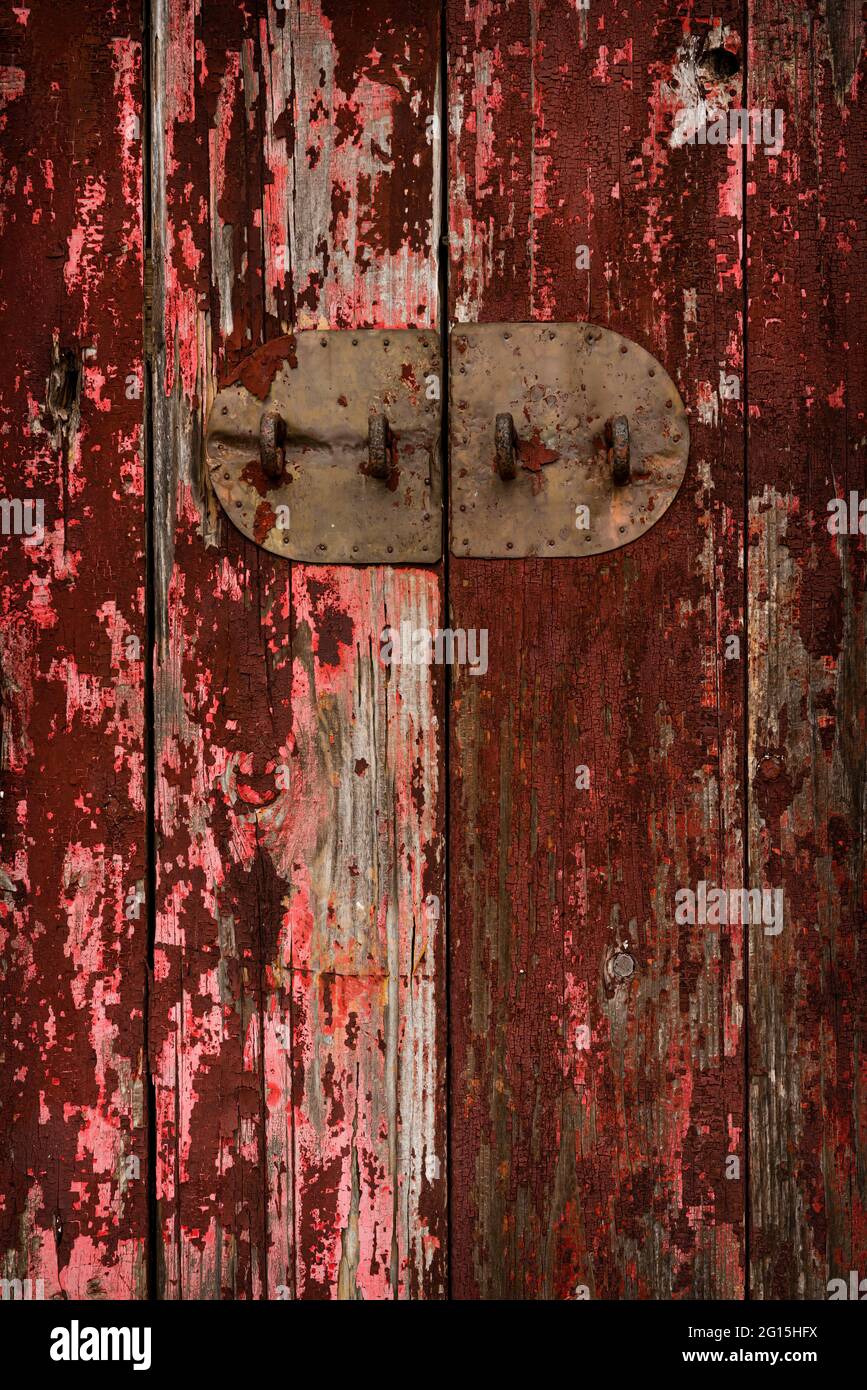 Detail of a weathered wooden door with the metal backplate of a simple bolt lock, Sham Chung Wan, New Territories, Hong Kong Stock Photo