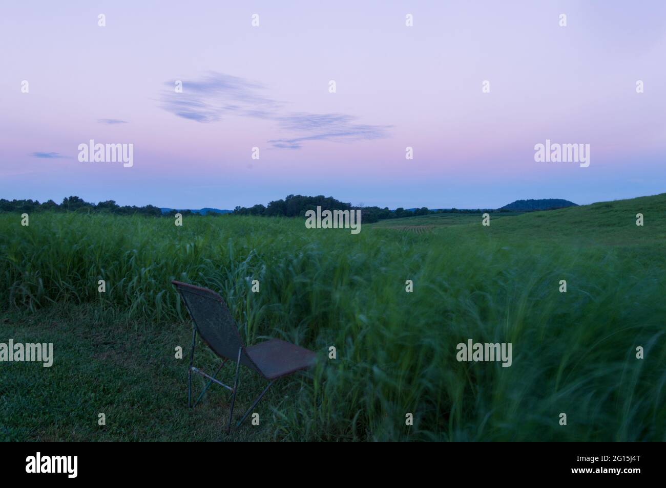 Abbey of Gethsemani, near Bardstown, Kentucky, chair sitting at the edge of a grassy field, sunrise, place of quiet and meditation Stock Photo