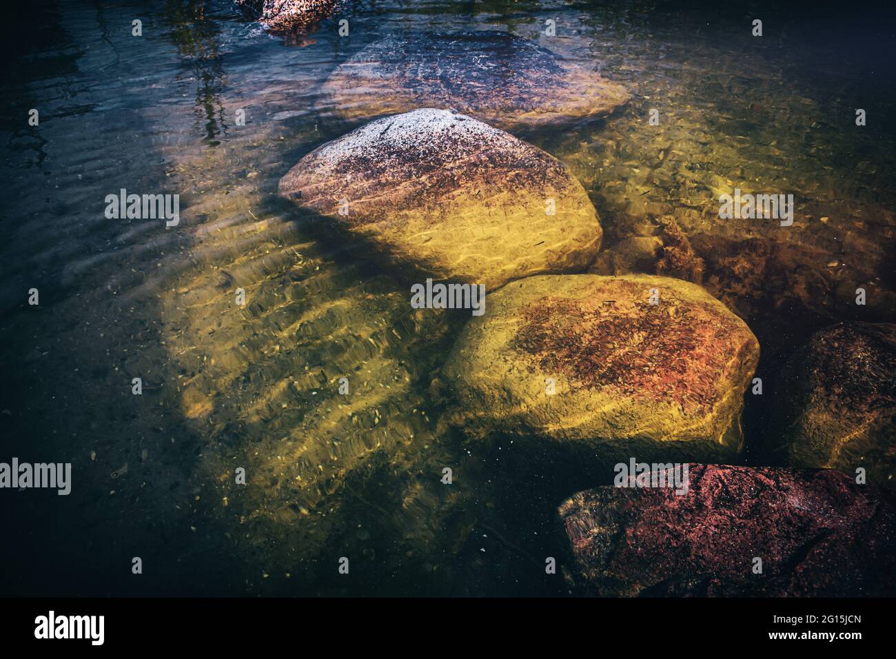 Große Felsen Steine liegen in einem klaren, durchsichtigen See unter Wasser. Grüner Stein im See unter Wasser die mit Moos bewachsen sind. Stock Photo