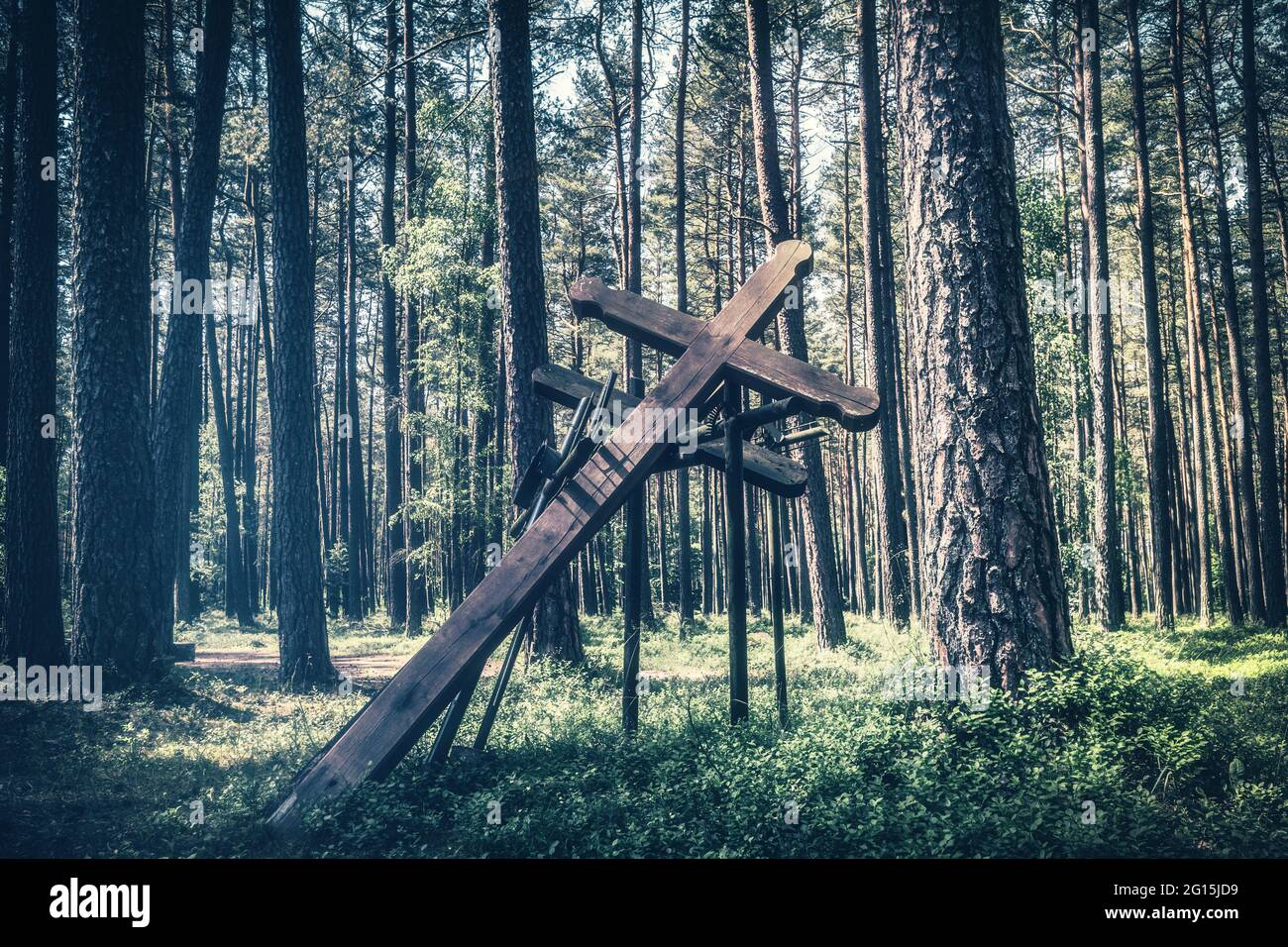 Holzkreuz als Denkmal und Monument im polnischen Wald. Gedenkstätte und Mahnmal für die Opfer der Nazis im zweiten Weltkrieg. Stock Photo
