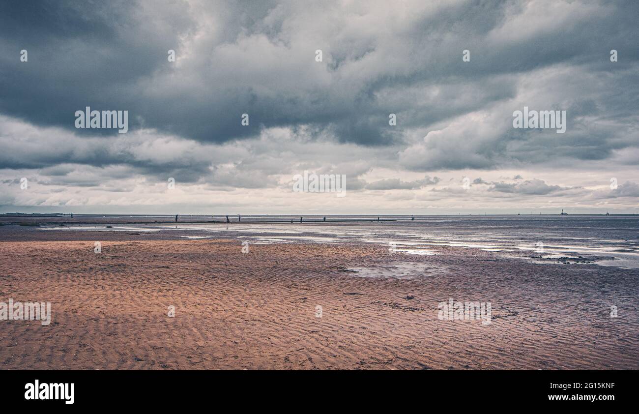 Cuxhaven beach on the German North Sea coast. Sandy beach with Kugelbake, a wooden beacon, stands at the mouth of the Elbe in the muddy mudflats. Stock Photo